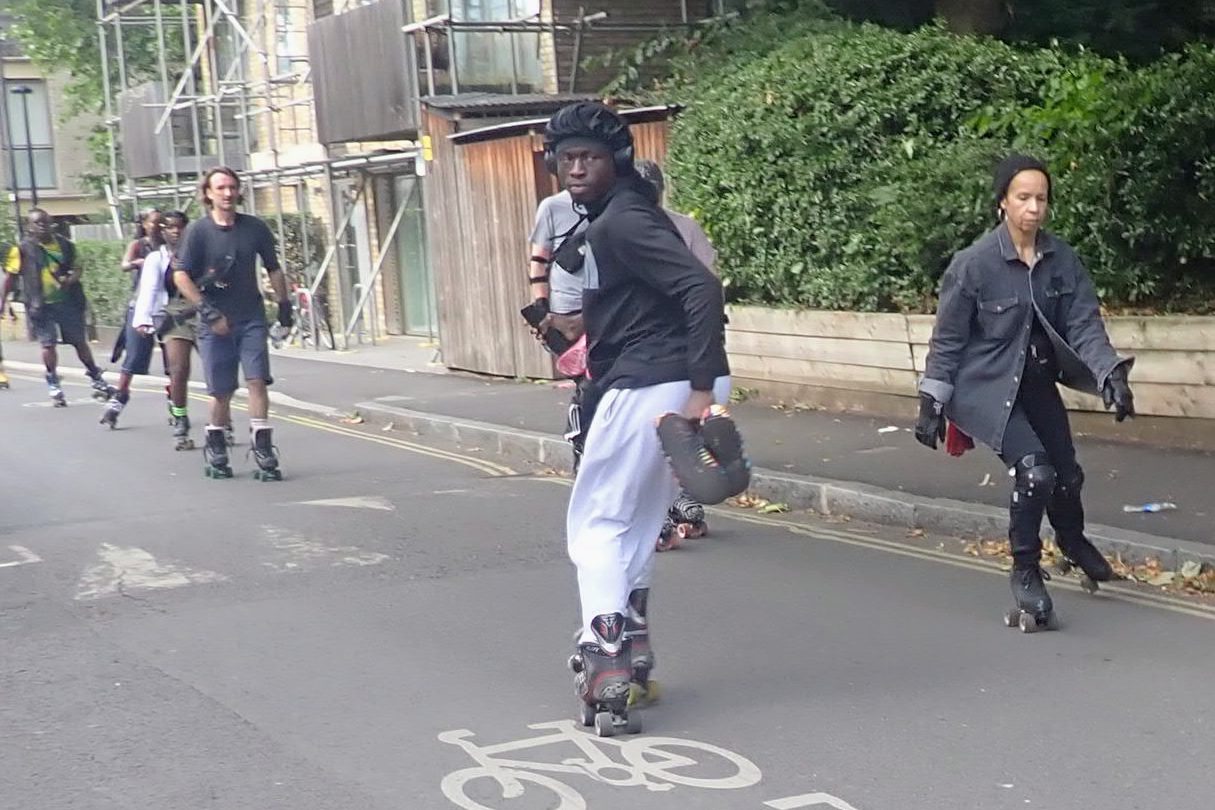 Someone skating backwards, skating southward from Elephant and Castle to Burgess Park. They are surrounded by other skaters.
