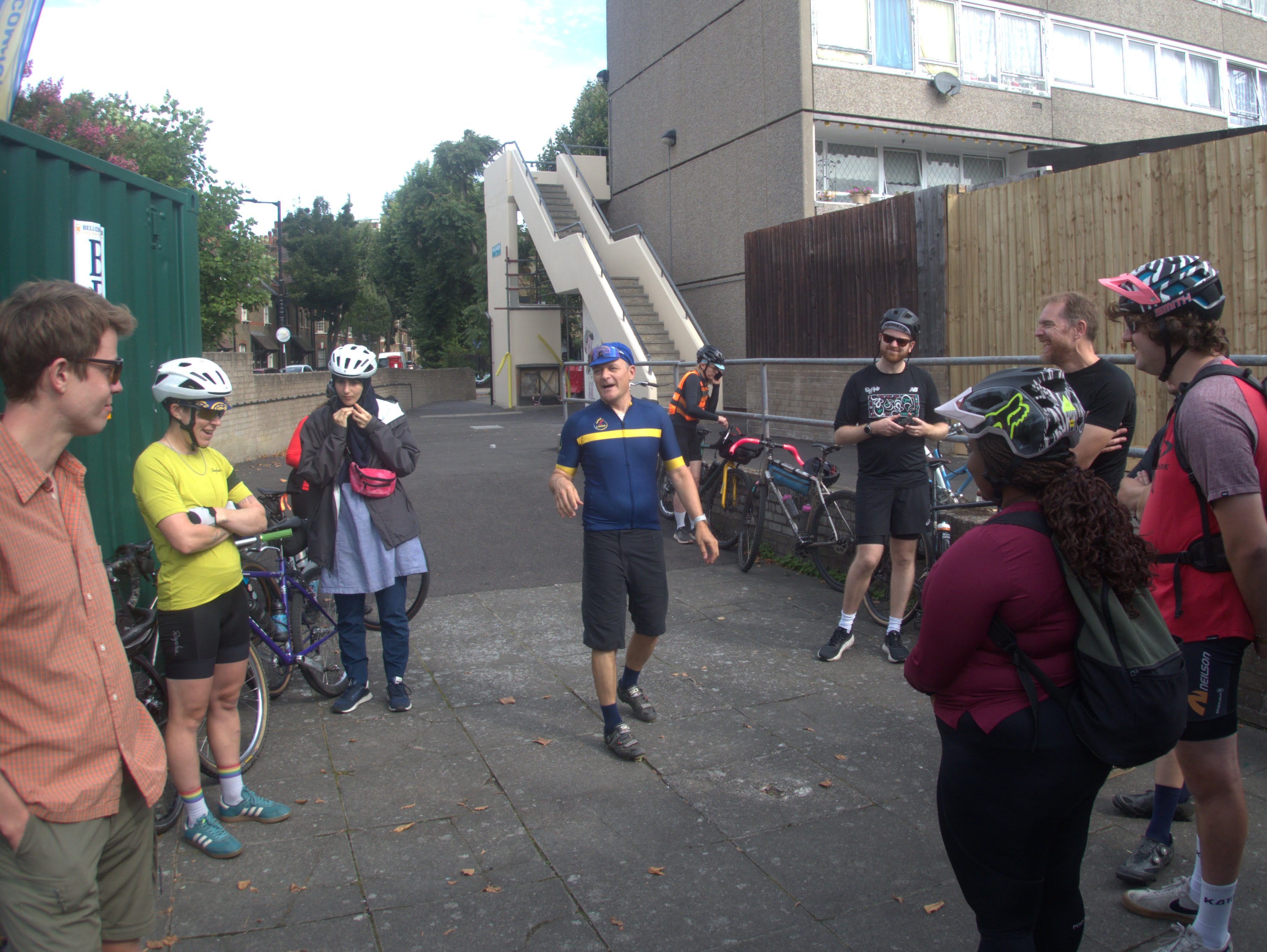 People gathered at the start of the 'project to project' bike ride. They are being briefed by Stewart, the boss