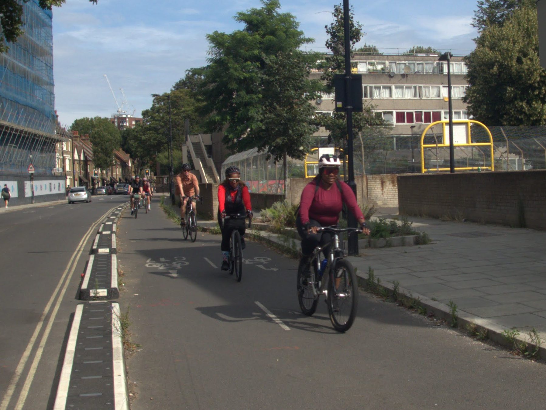 People riding south down a protected cycleway in Burgess Park, London