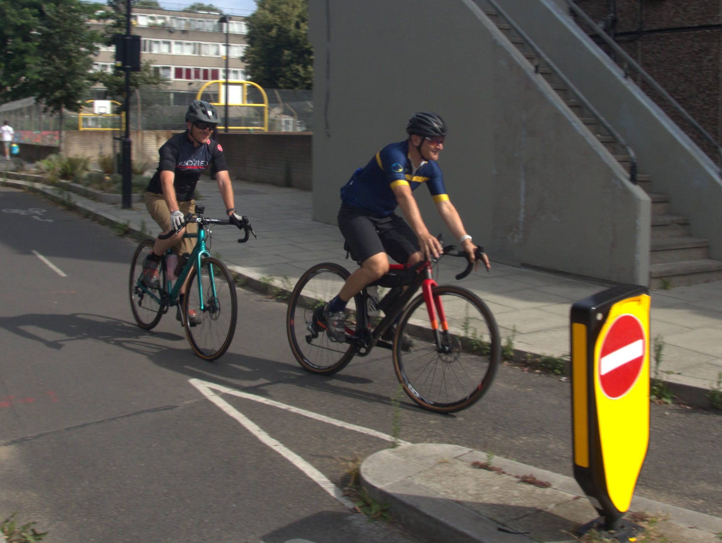 Two people riding on a protected cycleway in burgess park, London