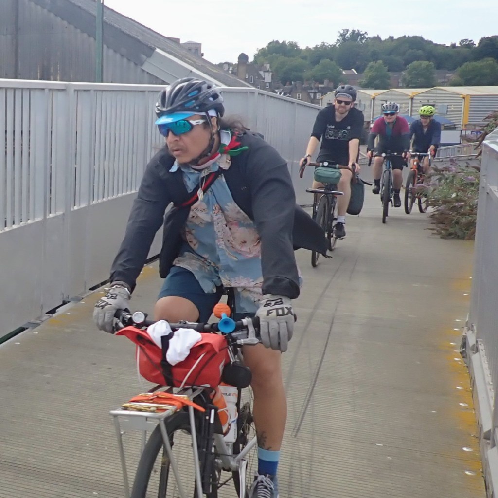 A convoy of cyclists navigating a cycleway in a single line.