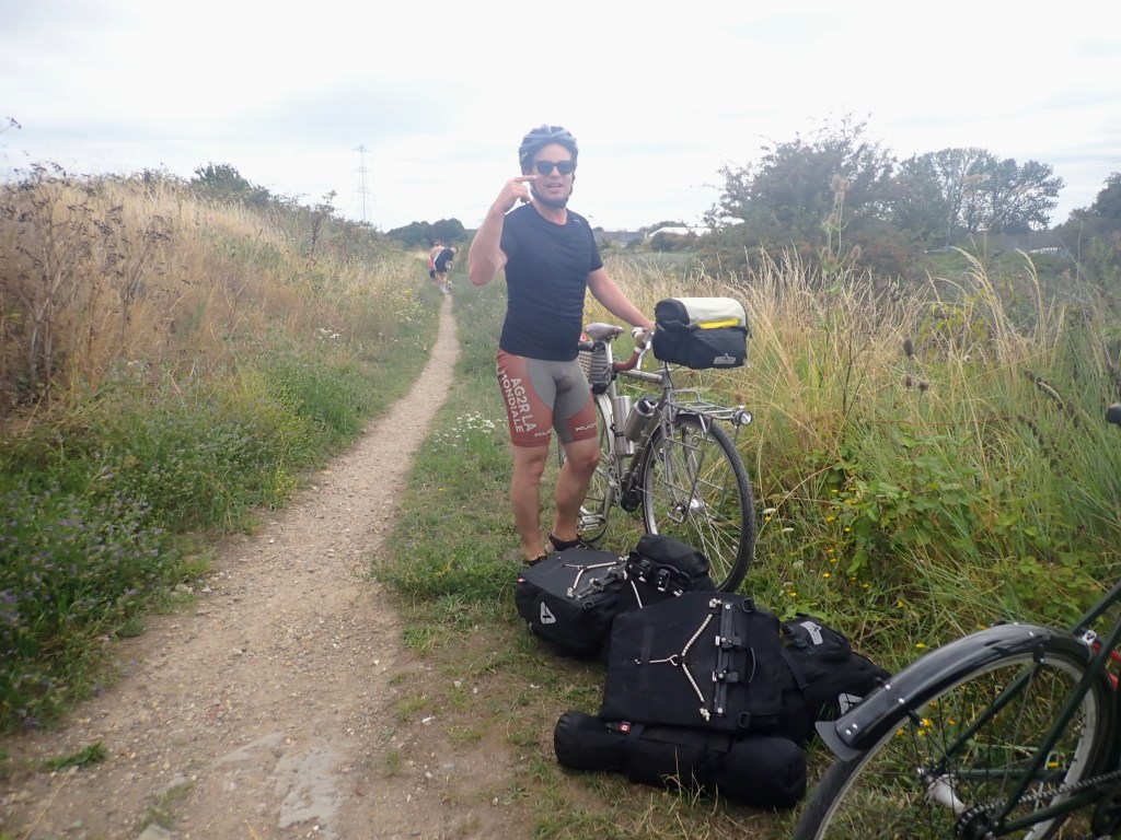 The same person from the previous shot but with their bike and panniers safely on the right side of the barrier.