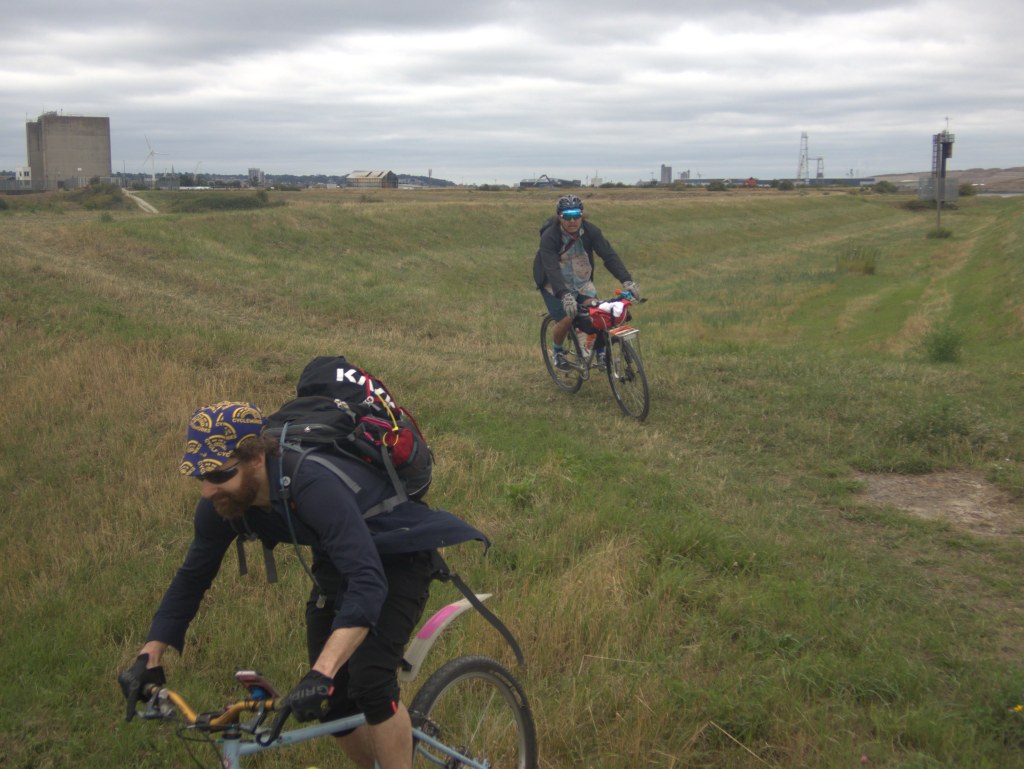 Photo of two people riding bikes off-road.