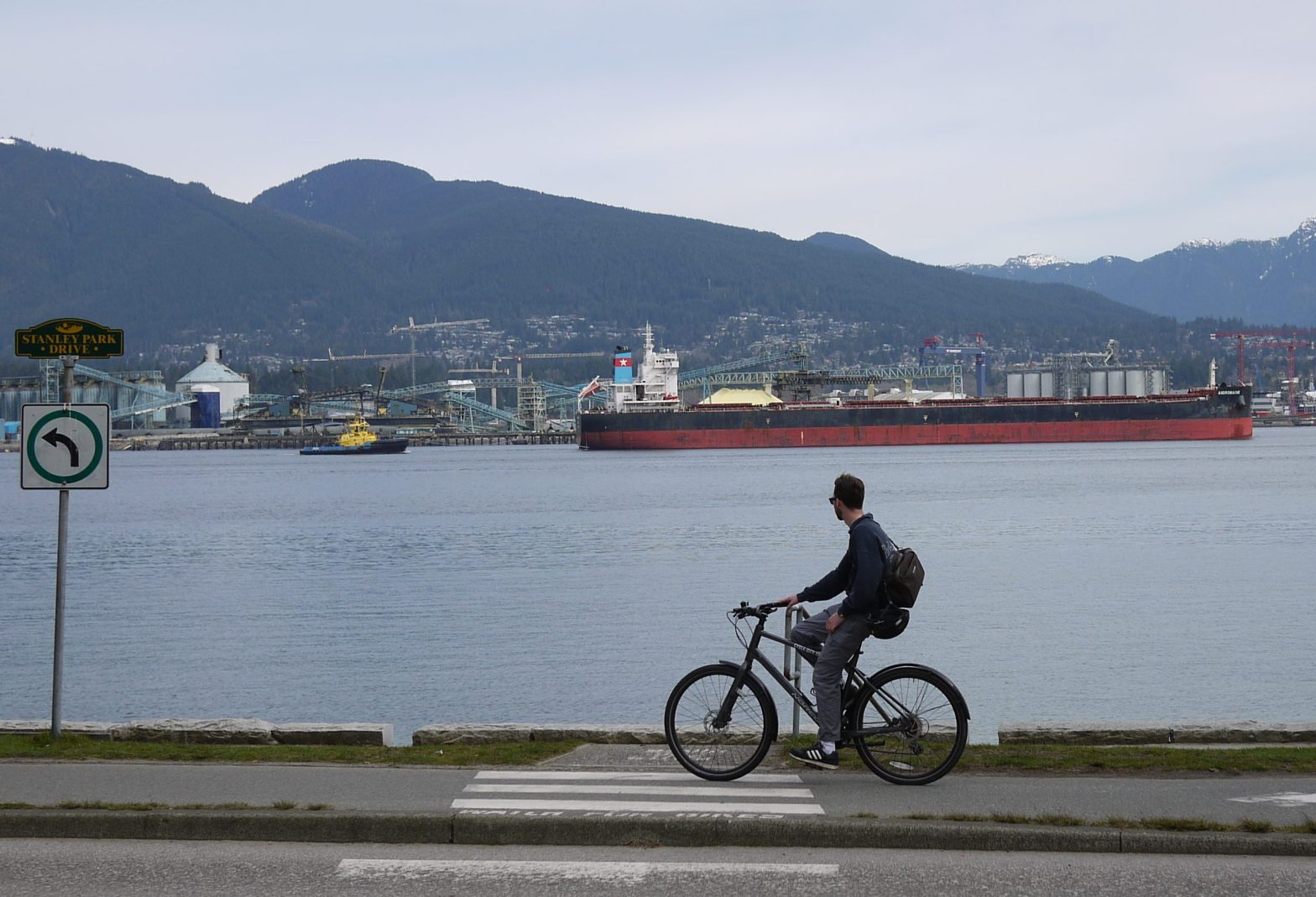 Photograph of someone cycling westward along the Vancouver sea wall.