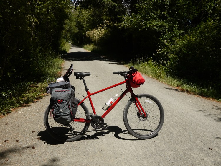 A bicycle on its kickstand on the 'galloping goose' cycle trail. The smoothness of the grave is crazy.